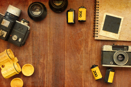 Blank notebook with photo film and camera on wooden background with sunlight vintage colorの写真素材