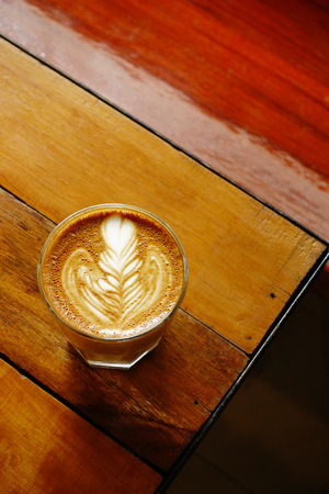 cup of latte art coffee on wooden backgroundの写真素材