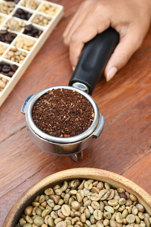 Freshly ground coffee beans in a metal filter and coffee beansの写真素材