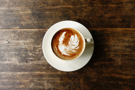cup of latte art coffee on wooden backgroundの写真素材
