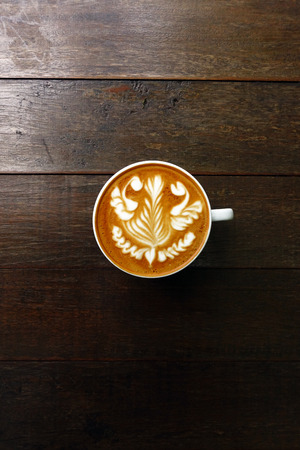 cup of latte art coffee on wooden backgroundの写真素材
