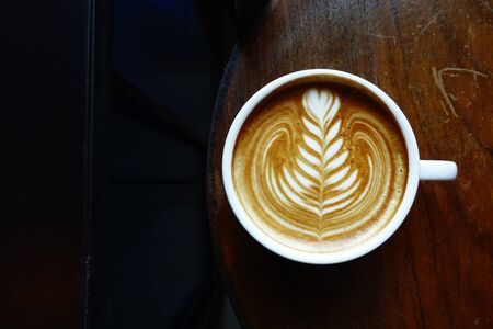 cup of latte art coffee on wooden backgroundの写真素材