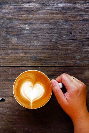 cup of latte art coffee on wooden backgroundの写真素材