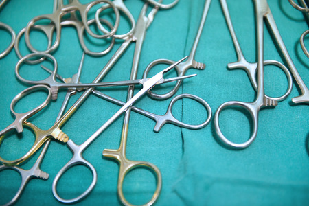 Detail shot of steralized surgery instruments with a hand grabbing a toolの写真素材