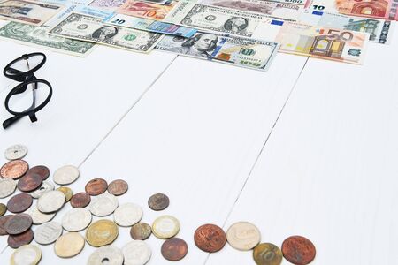 Banknote and coin with glasses isolated on white backgroundの写真素材