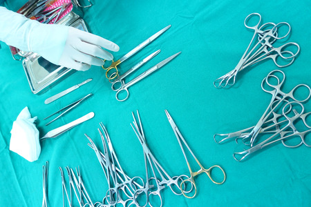 Detail shot of steralized surgery instruments with a hand grabbing a toolの写真素材