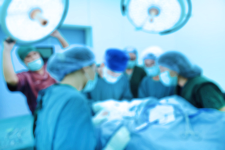Blur of group of veterinarian surgery in operation room take with art lighting and blue filterの写真素材