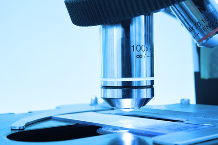 close up shot of microscope at the blood laboratory take with art lighting and blue filter