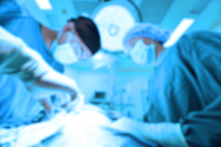 Blur of two of veterinarian surgery in operation room take with art lighting and blue filterの写真素材