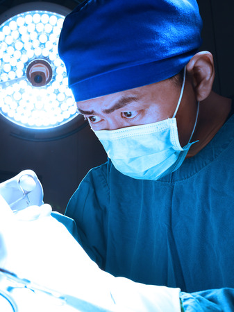 veterinarian surgeons in operating room take with art lighting and blue filterの写真素材