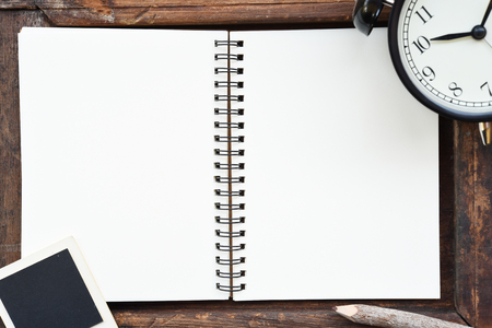 Blank notebook, photo frame, pencil and clock on wooden backgroundの写真素材