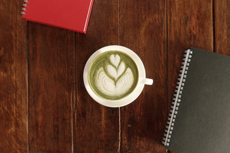 A cup of green tea matcha latte on wooden backgroundの写真素材
