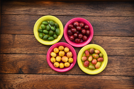 Coffee beans and fresh berries coffee beans on plate on wooden backgroundの写真素材