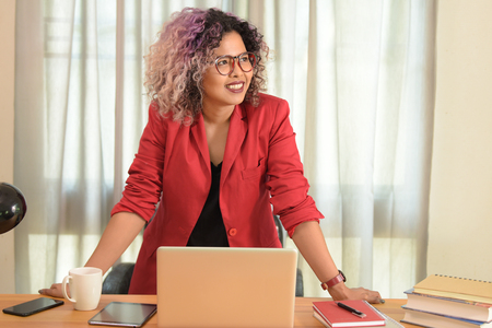 Portrait of female executive sitting at her desk in officeの写真素材