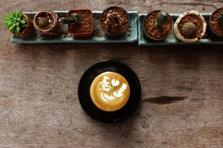 a cup of latte art coffee on wooden backgroundの写真素材