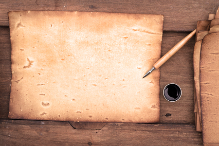 old paper on brown wood texture with pen and ink.の写真素材