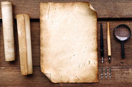 Vintage writing set with old paper on brown wood texture with feather and inkの写真素材