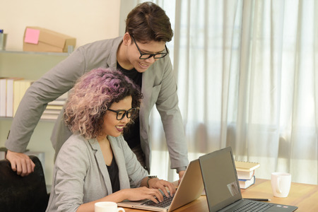 Two business people discussing about work in an office.の写真素材