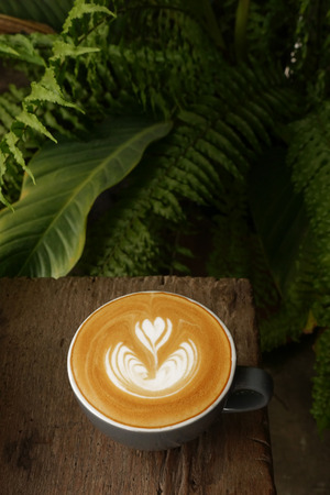 a cup of latte art coffee on wooden backgroundの写真素材