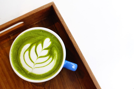 A cup of green tea matcha latte on wooden backgroundの写真素材
