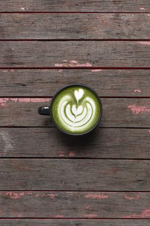 A cup of green tea matcha latte on wooden backgroundの写真素材