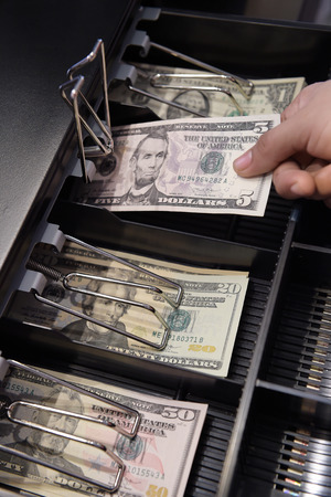 High angle view of cashier searching for change in cashの写真素材