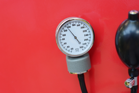 Blood pressure meter medical equipment on red backgroundの写真素材