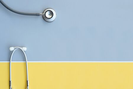 close up of stethoscope on gray and yellow background