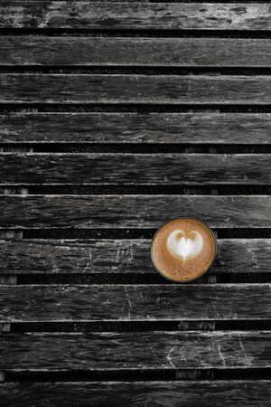 a cup of latte art coffee on wooden backgroundの写真素材