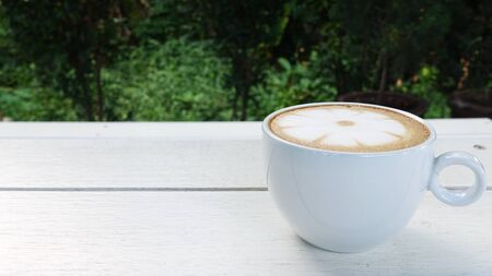 a cup of latte art coffee on wooden backgroundの写真素材