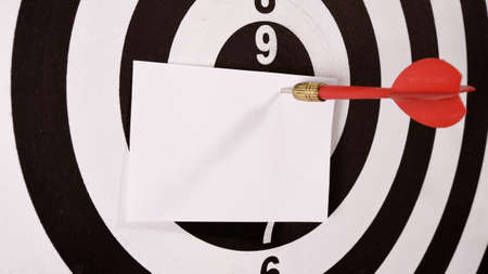 target red arrow and paper note on center of dartboardの写真素材