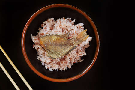 close up of fried fish with rice on the plate