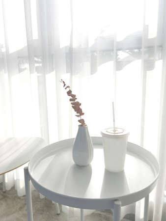 Interior with dry leaves in ceramic vase on the white tableの写真素材