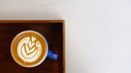 a cup of latte art coffee on wooden backgroundの写真素材