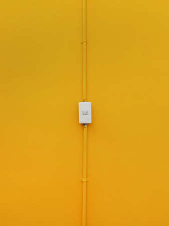 Close up white electricity switch on yellow color wall backgroundの写真素材