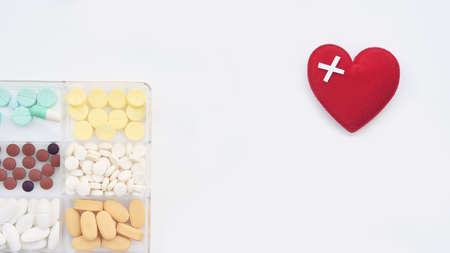 close up of different medication with red heart isolated on white backgroundの写真素材