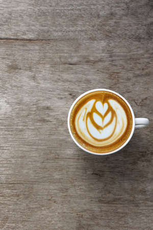 a cup of latte art coffee on wooden backgroundの写真素材
