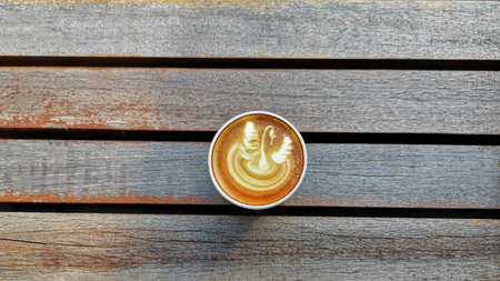 a cup of latte art coffee on wooden backgroundの写真素材