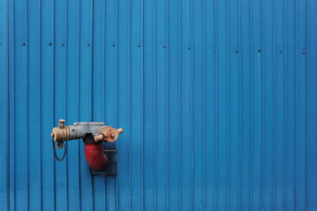 Fire hydrant attached on blue wall backgroundの写真素材