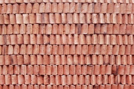 close up of wall clay stack of red clay bricks in rows for backgroundの写真素材