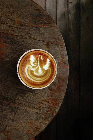 a cup of latte art coffee on wooden backgroundの写真素材