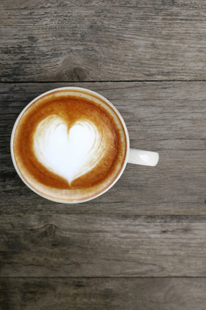 a cup of latte art coffee on wooden backgroundの写真素材