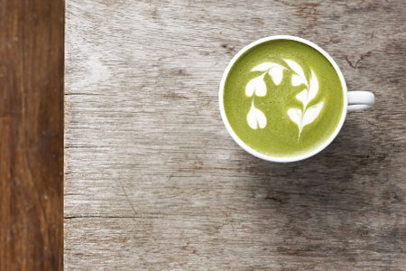 A cup of green tea matcha latte on wooden background