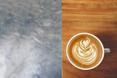 a cup of latte art coffee on wooden backgroundの写真素材