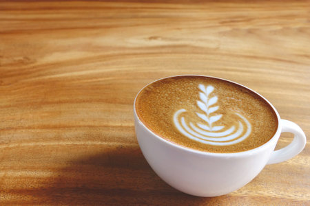 a cup of latte art coffee on wooden backgroundの写真素材