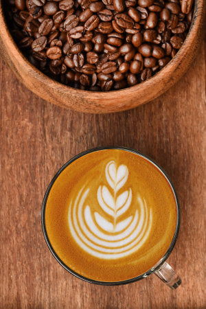 a cup of latte art coffee on wooden backgroundの写真素材
