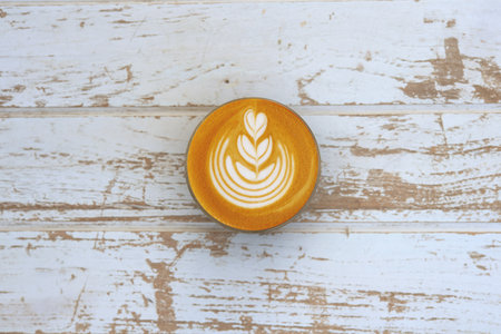 a cup of latte art coffee on wooden backgroundの写真素材
