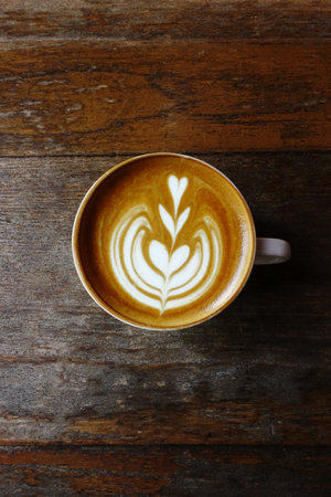 a cup of latte art coffee on wooden backgroundの写真素材