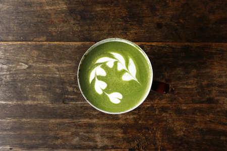 A cup of green tea matcha latte on wooden backgroundの写真素材