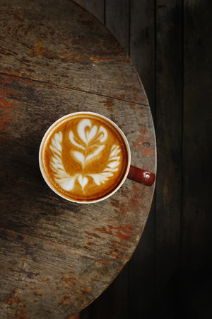 a cup of latte art coffee on wooden backgroundの写真素材
